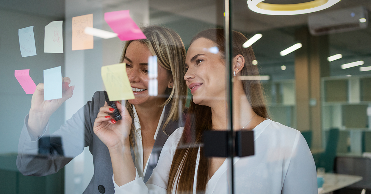 dos mujeres escribiendo en post-its